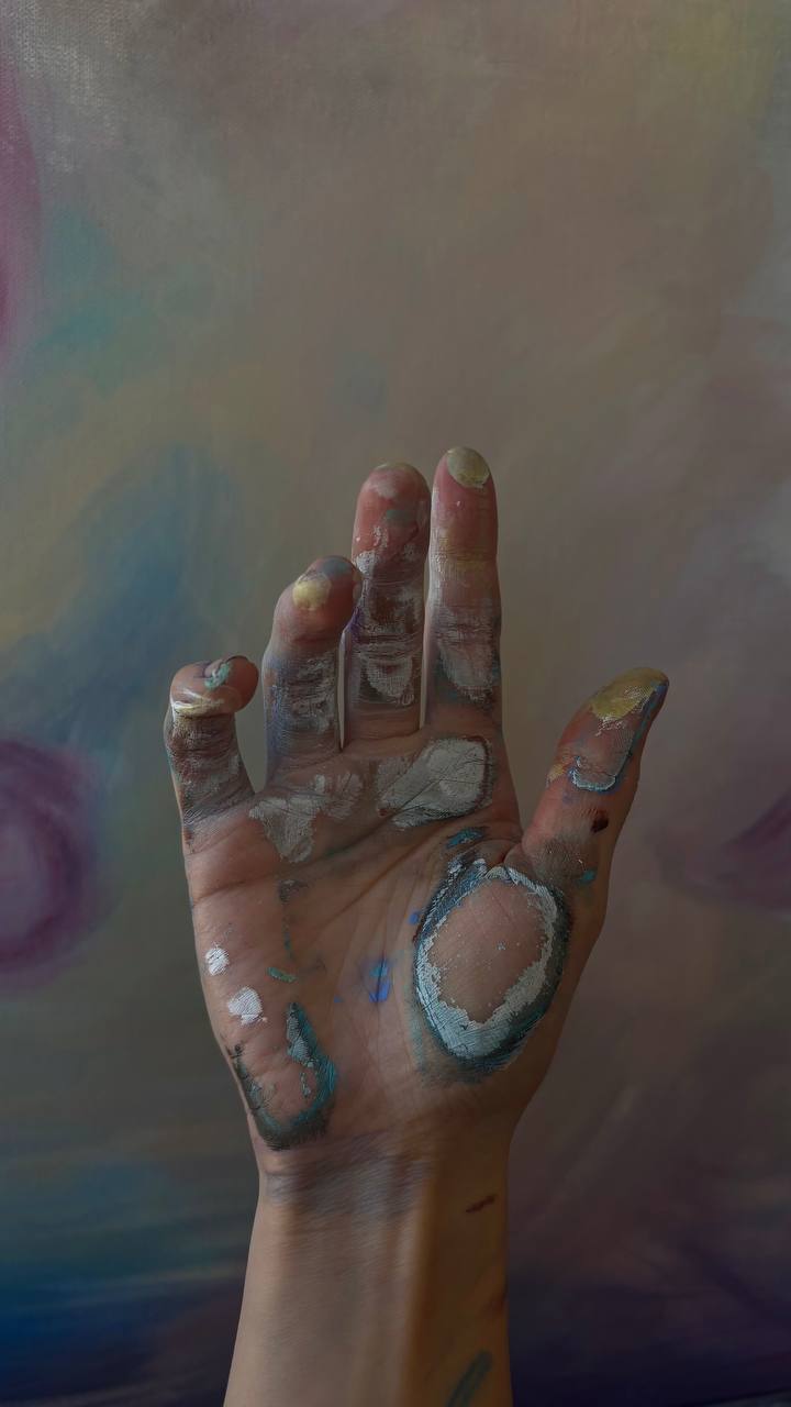 Maryia Zaloznaya's paint-covered hand in the studio